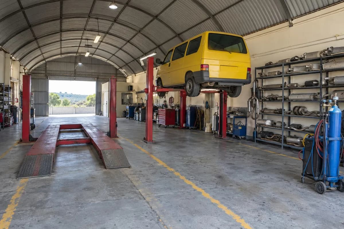 A oficina debaixo do telhado curvo de chapa, rampas vermelhas e linhas amarelas no chão